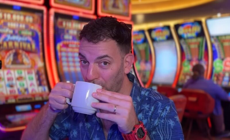 Brian Christopher Slots drinks from a cup in casino