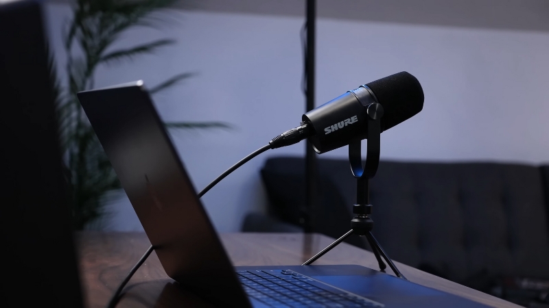 A Shure Microphone Next to A Laptop, Set up For Podcast Recording