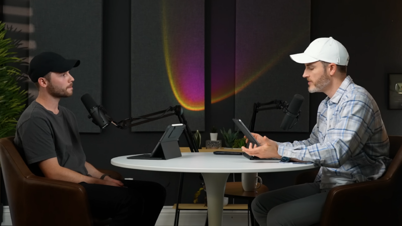 Two People Sitting at A Table in A Podcast Studio