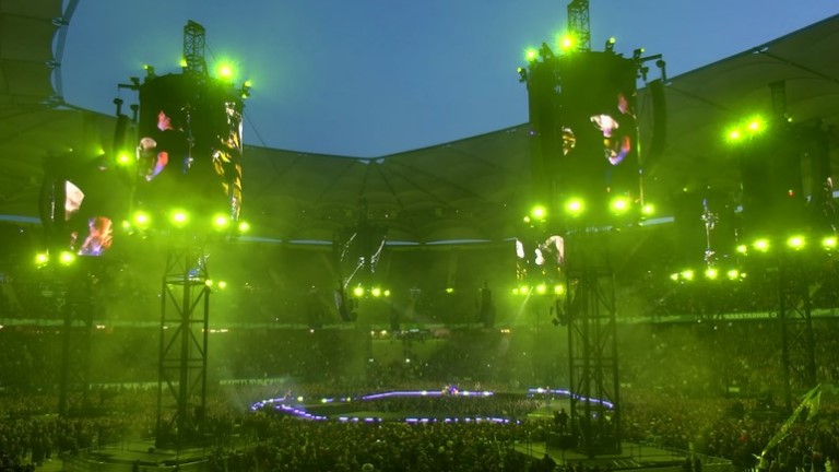 Massive stage structure bathed in vibrant lime-green light