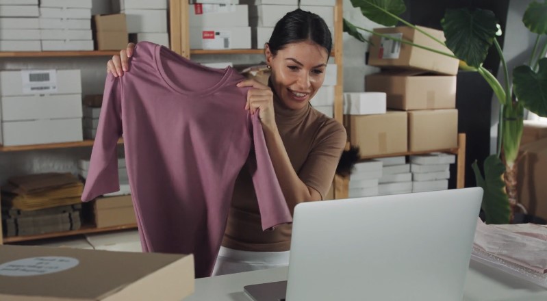 Woman inspecting a mauve-colored long-sleeve top