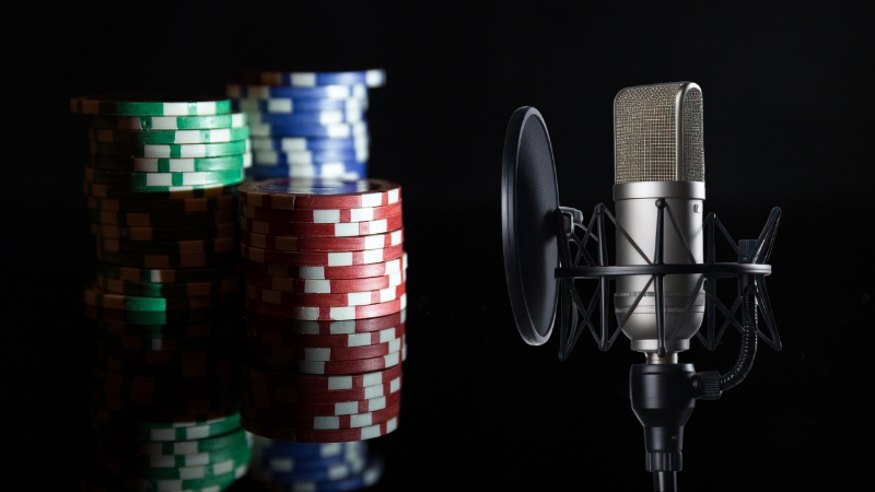 A podcast mic sits next to stacks of poker chips, capturing the theme of online gambling and iGaming culture