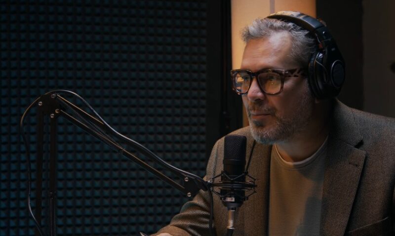 Attentive host in a soundproof booth, ready to share insightful commentary