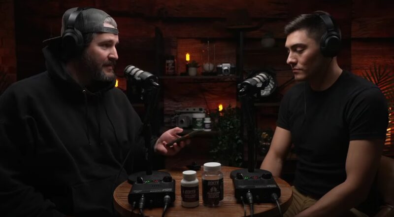 Two hosts, engrossed in conversation, microphones illuminating their focused expressions