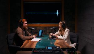 Two podcasters, engaged in lively conversation, bathed in the warm glow of the studio lights