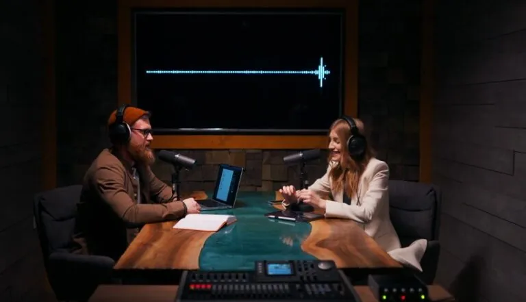 Two podcasters, engaged in lively conversation, bathed in the warm glow of the studio lights