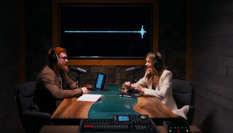 Two podcasters, engaged in lively conversation, bathed in the warm glow of the studio lights