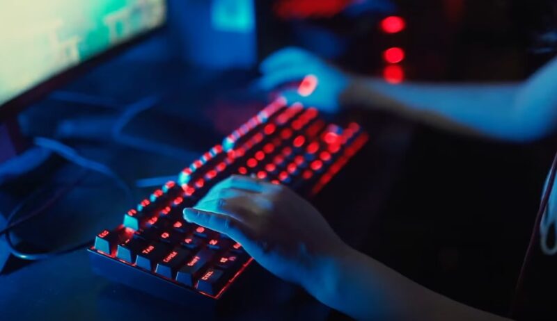 Close-up view of hands typing on a backlit keyboard