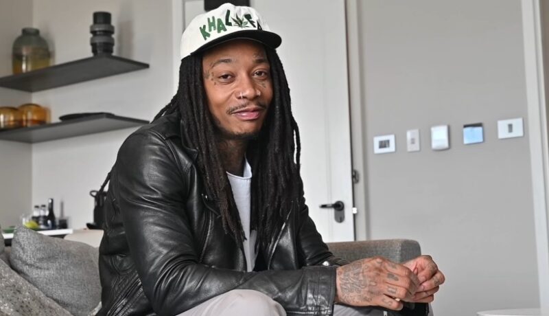 Wiz Khalifa looking at the camera while sitting in his living room