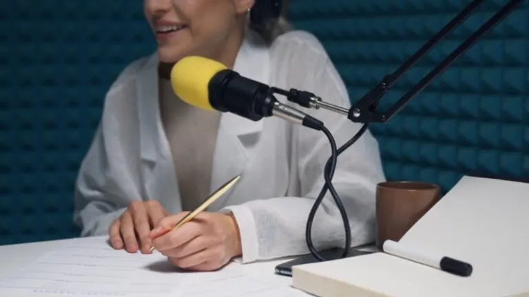 Woman recording with a microphone and notes on desk during a discussion about podcast hosting platform