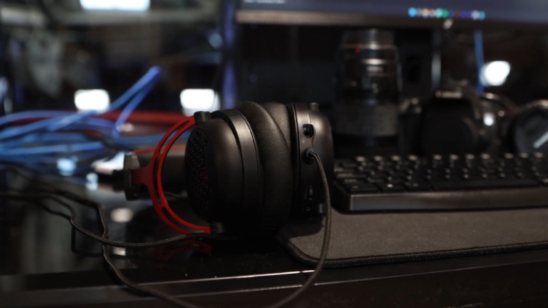 Headphones on a desk near a keyboard and recording equipment for a podcast host