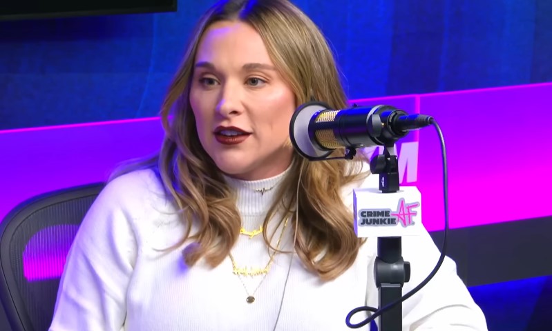 Ashley Flowers sitting in front of a microphone