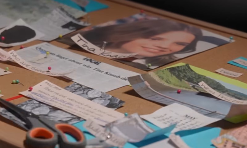 A bulletin board displaying a picture of a woman prominently featured among various notes and announcements