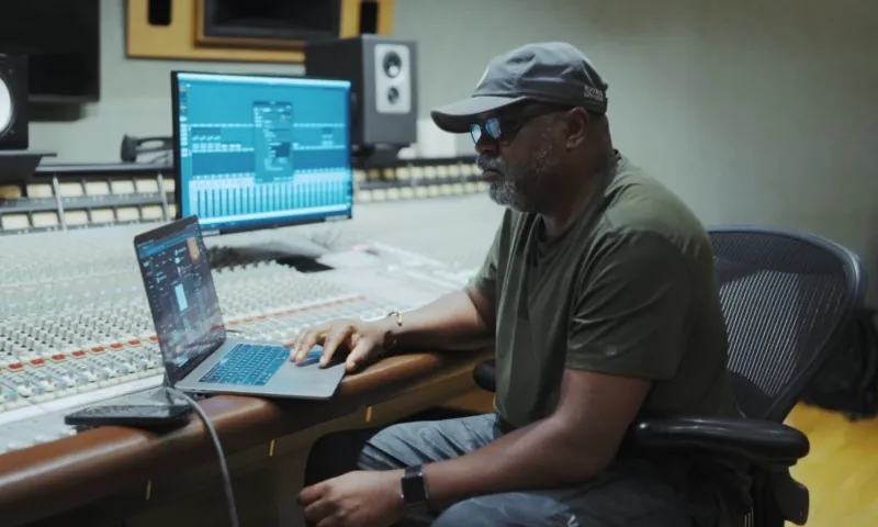 Music producer using Suno AI in a studio